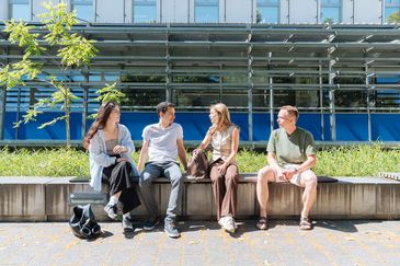 Gruppe Studierender unterhalten sich auf dem Hauptcampus.