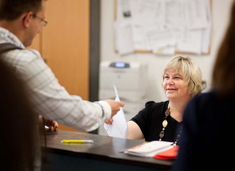 Studierender lässt sich an Theke beraten