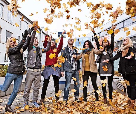 Gruppe Studierende stehen vor der FH im Herbst